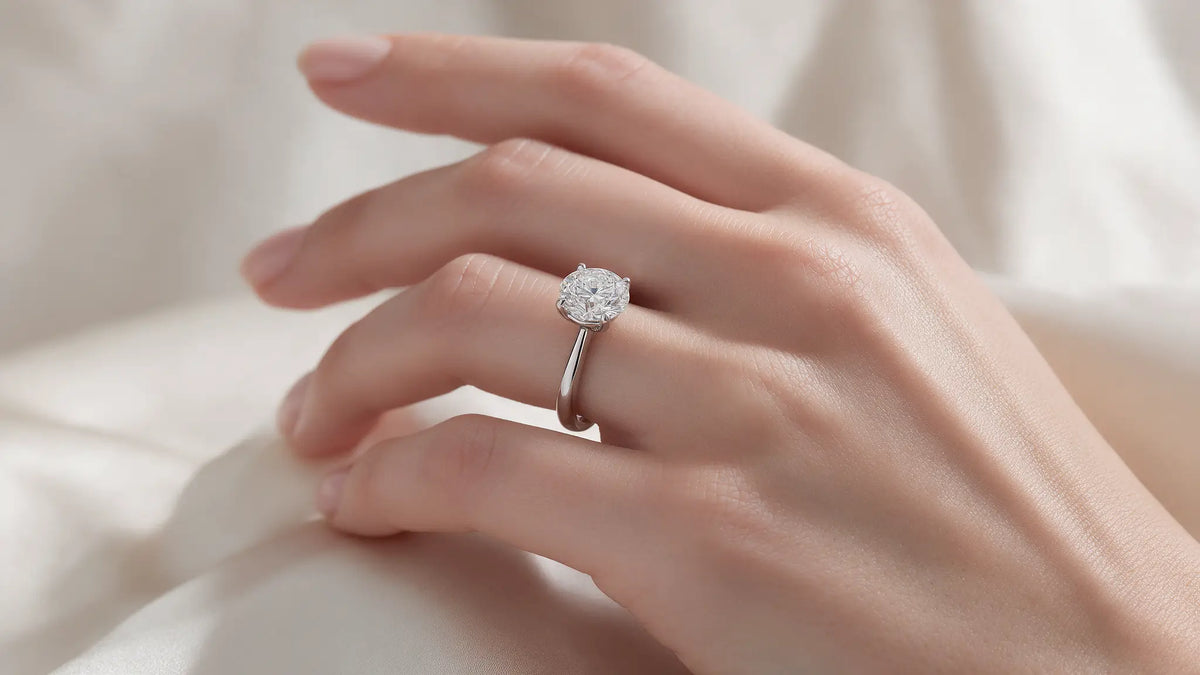 Halo diamond engagement ring with a matching band on dark wood
