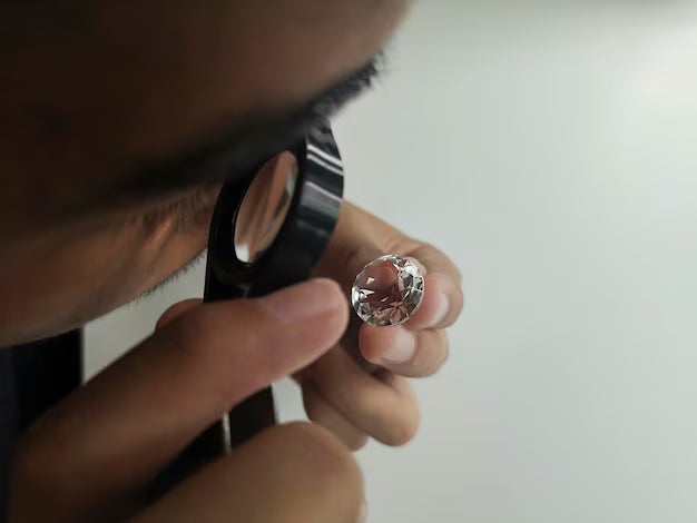 Gemmologist inspecting a diamond through a loupe