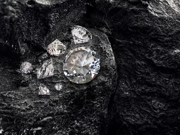 Rough and polished diamonds on dark stone